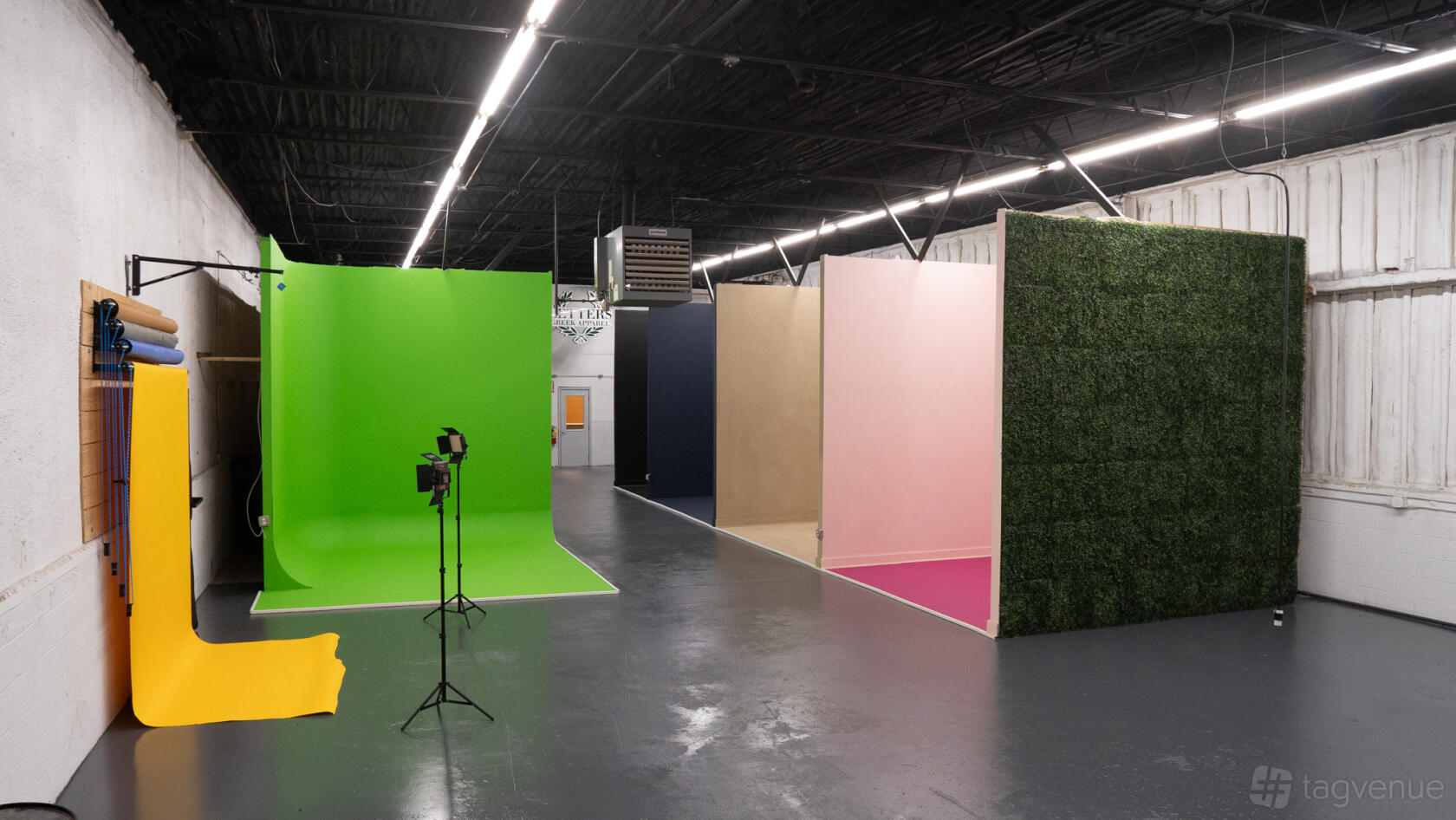 A film studio with multiple backdrop walls in green, pink, navy, beige, and artificial greenery at South Atlanta Industrial Photo & Film Studio.