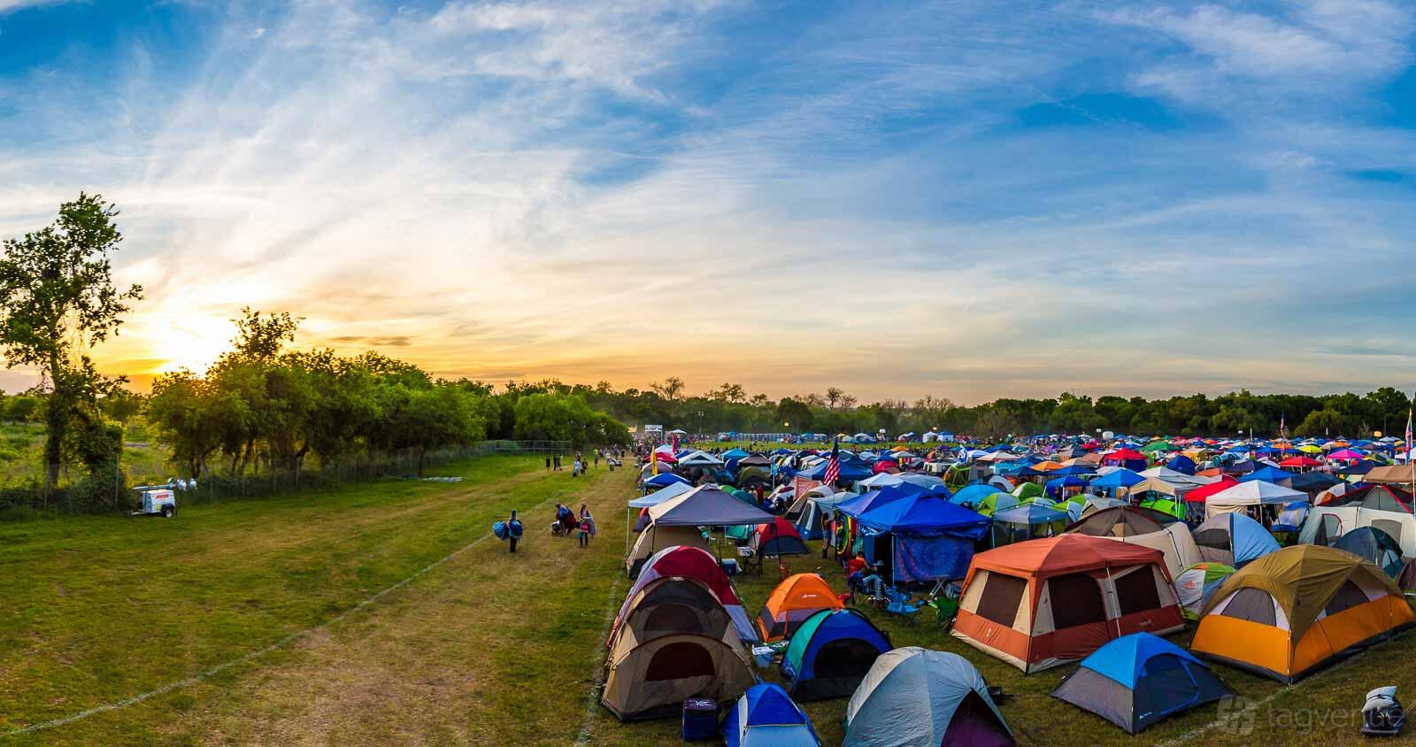 An outdoor venue with colorful camping tents set up on grass fields at Carson Creek Ranch