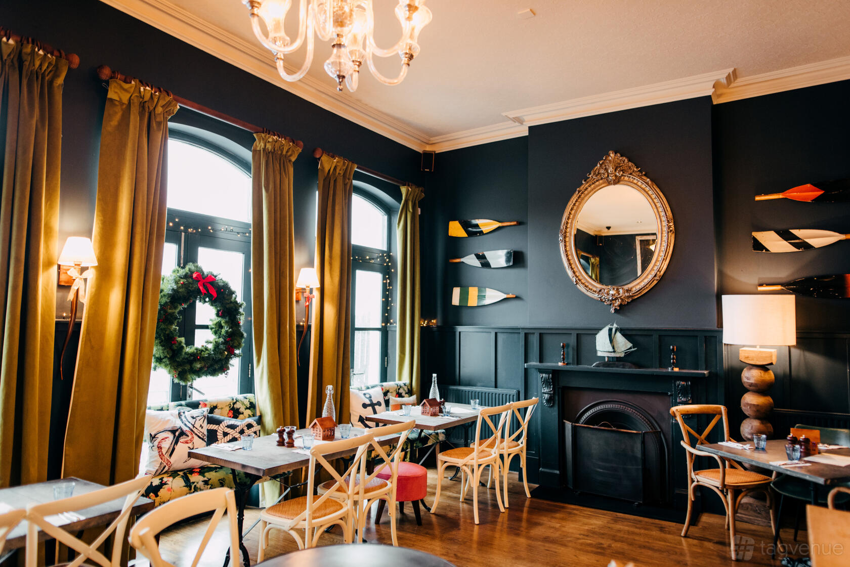 An event space in a pub with dark walls, large windows, and nautical decor at The Blue Anchor.
