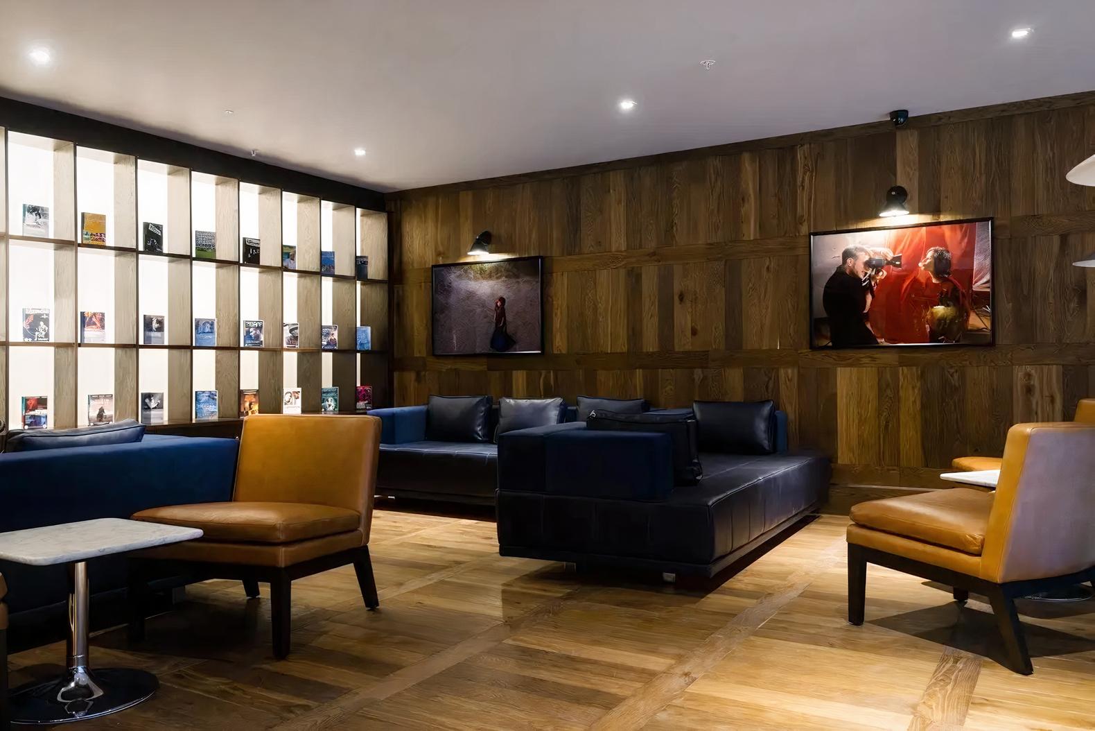 An event space in a cinema with wood-paneled walls, lounge seating, and art displays at Curzon Victoria.