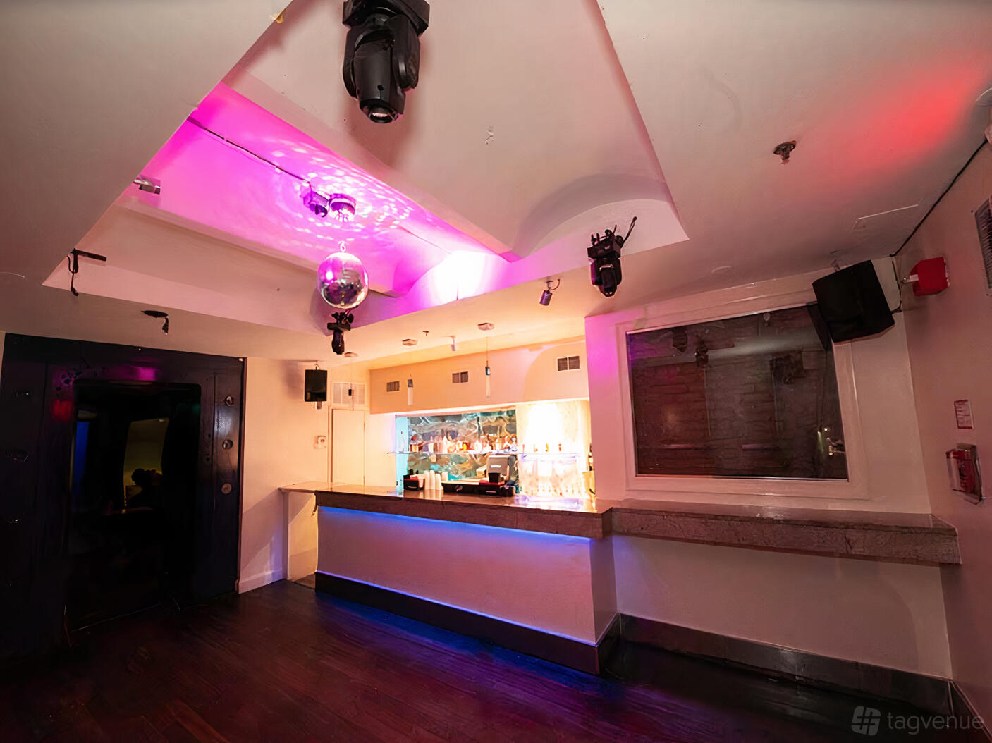 A nightclub basement with a lit bar, disco ball, and pink uplighting at Ultrabar.