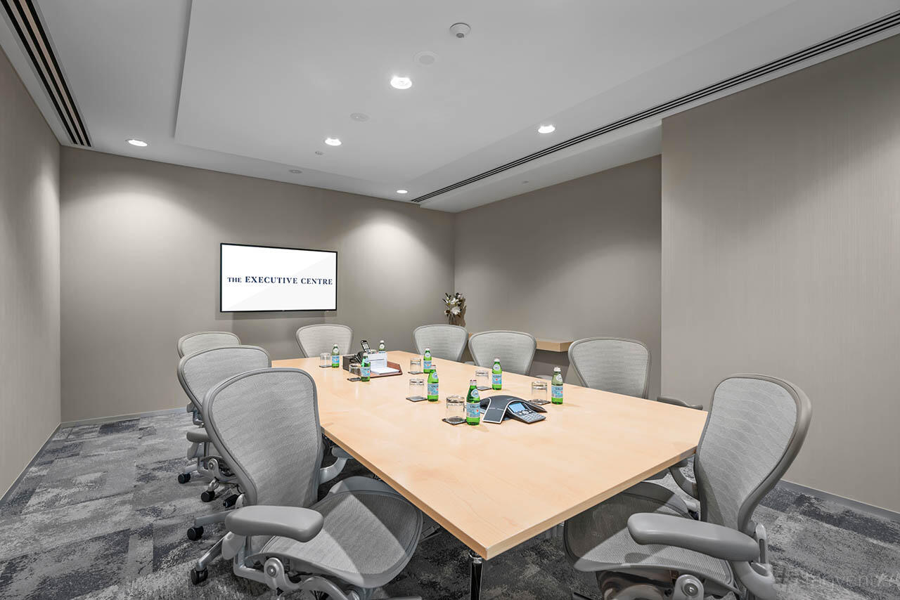 A meeting room with a rectangular table, ergonomic chairs, and a wall-mounted screen at 108 St Georges Terrace.