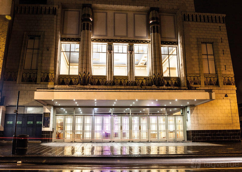 A conference centre with an illuminated art deco facade and large glass doors at Gracepoint.