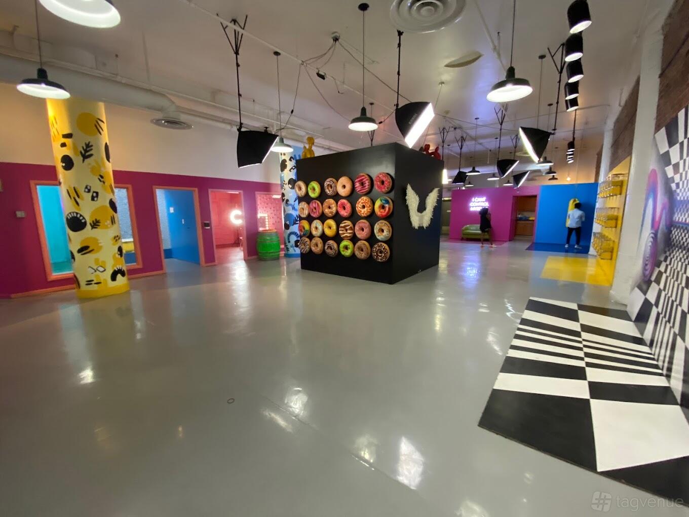 A museum with colorful walls, large photography lights, and playful interactive backdrops at Denver Selfie Museum.