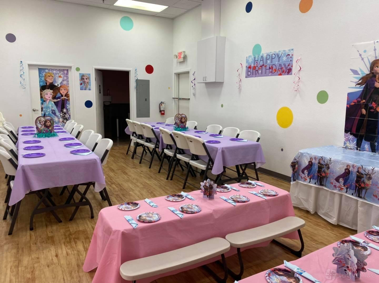 An indoor event venue with decorated birthday tables, colorful wall decals, and themed party decor at Fidgets Indoor Playground & Party Place.