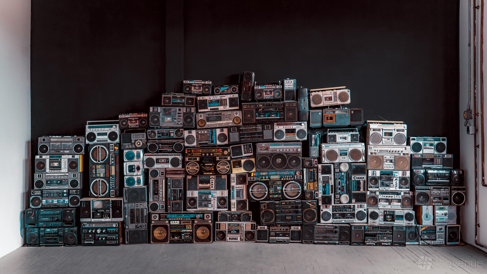 A photo studio with a floor-to-ceiling wall display of vintage boomboxes at The Boombox Room Ingraham Street.