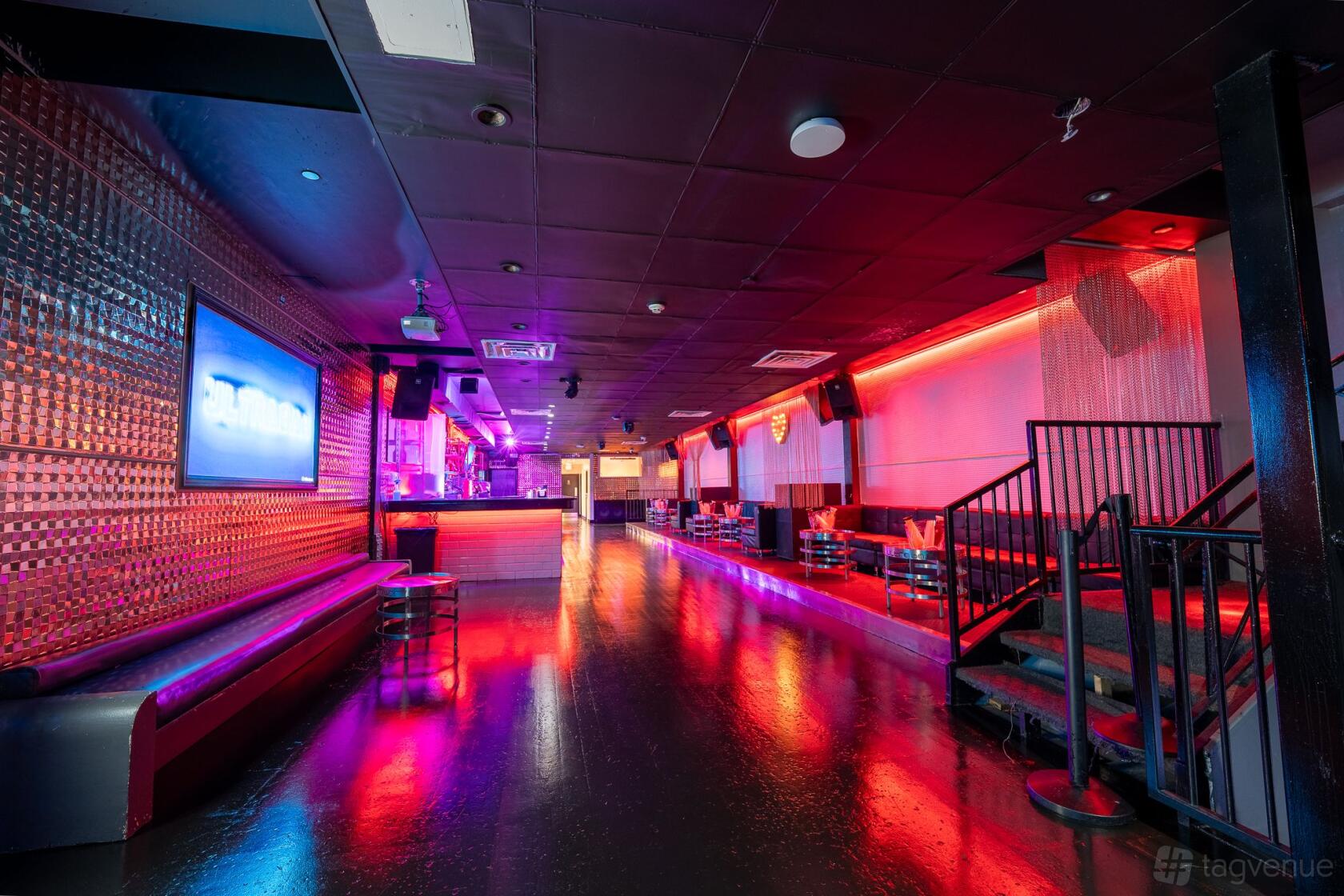 A nightclub event space with neon lighting, metallic wall panels, and lounge seating at Ultrabar.