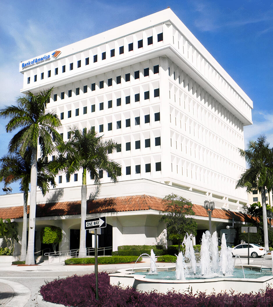 A white office building with grid windows and palm trees at ZEN Offices Boca Raton