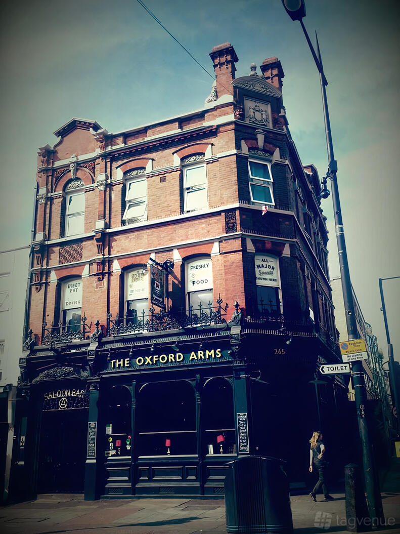 A theatre housed in a red brick Victorian building with large windows and decorative ironwork at The Etcetera Theatre.