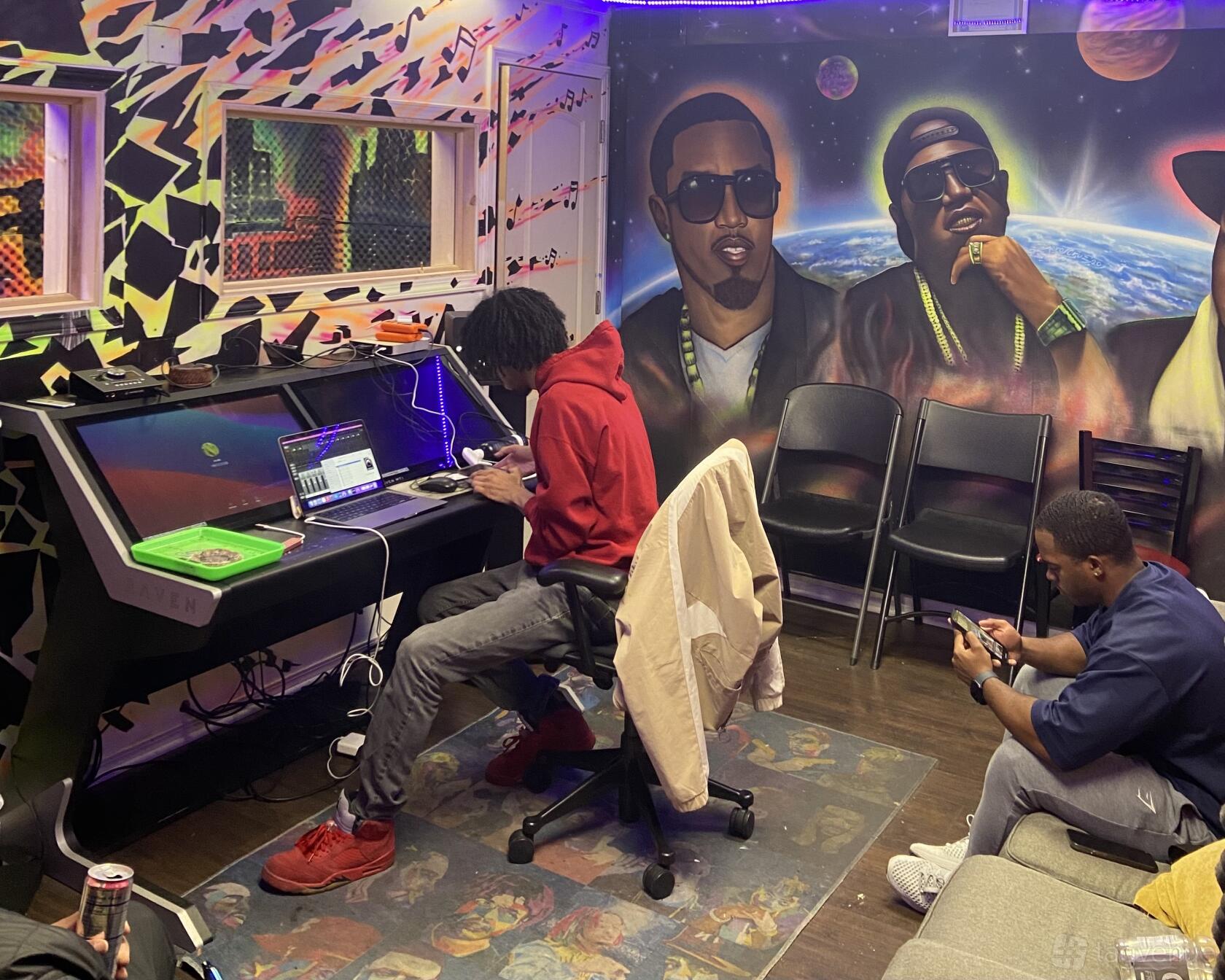 A recording studio with a mural of hip hop artists, acoustic panels, and a mixing console at 700 Green Studios.