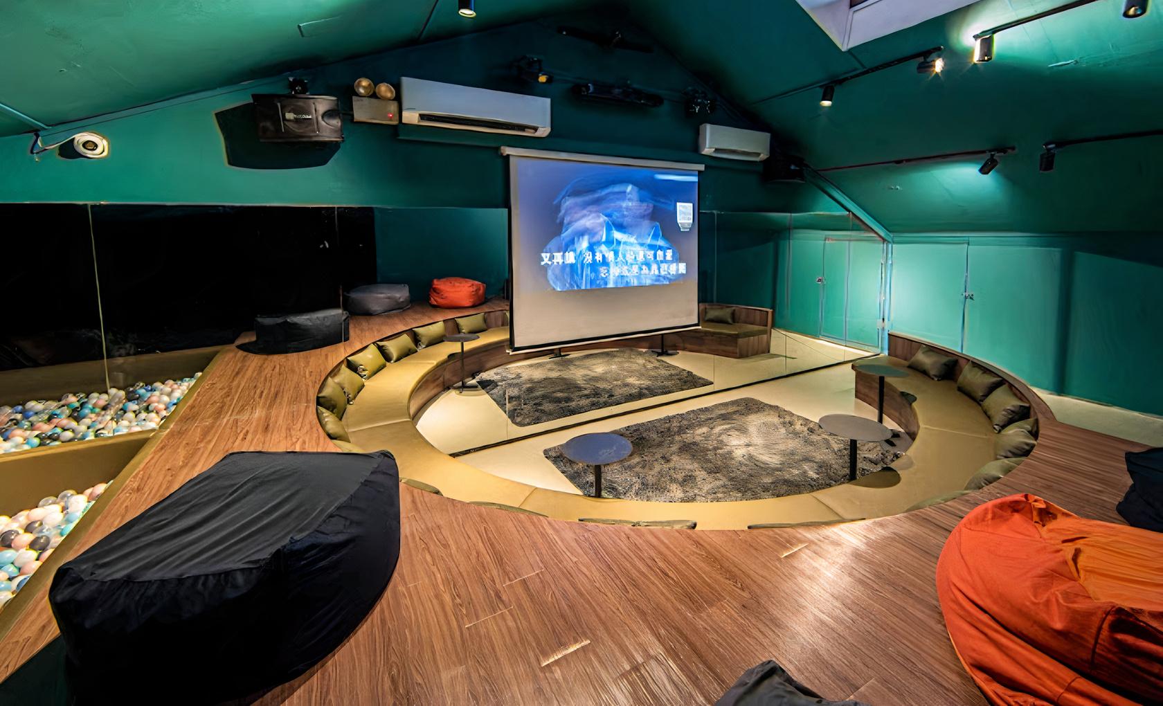An event venue with a sunken seating area, bean bags, and a projector screen at 21&Above.