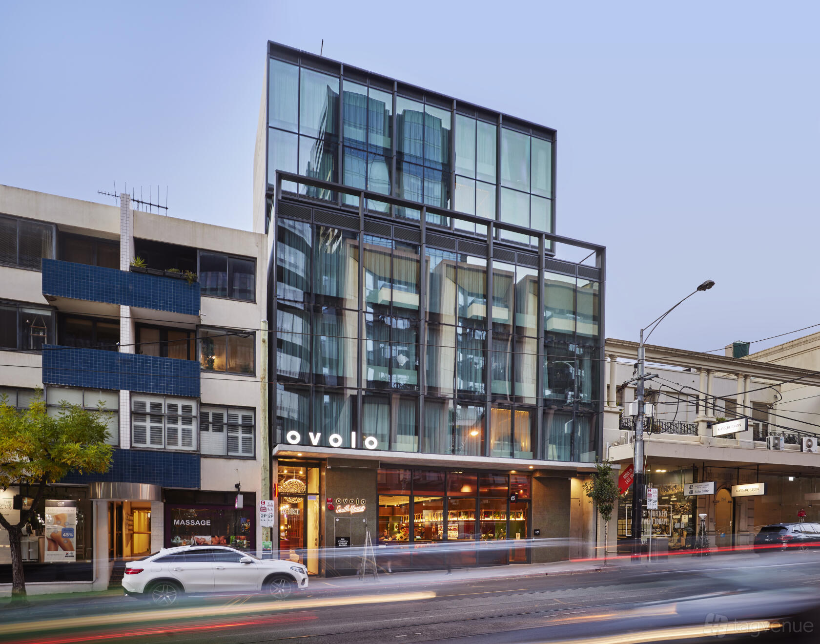 A hotel with a glass facade and ground floor entrance along a busy street at Ovolo South Yarra.