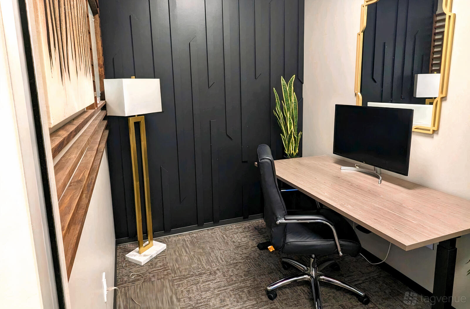 A coworking creative space with a modern desk, office chair, gold floor lamp, and potted plant at Lucid Private Offices - Downtown/Main Street.