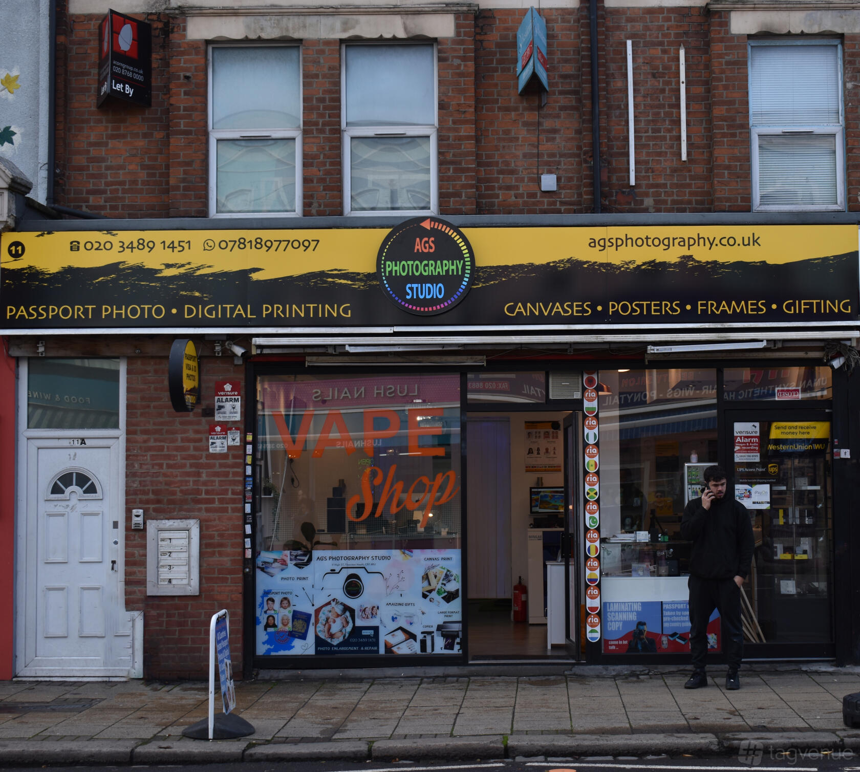 A film and photo studio with a yellow and black signage above a glass storefront at AGS Photography Studio.