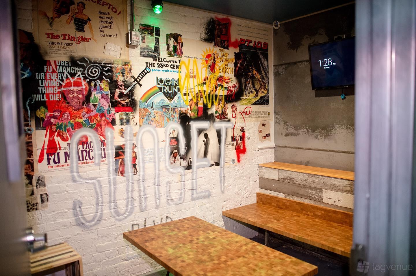 An event venue with graffiti-style wall art, wood benches, and a TV screen at RPM Underground.