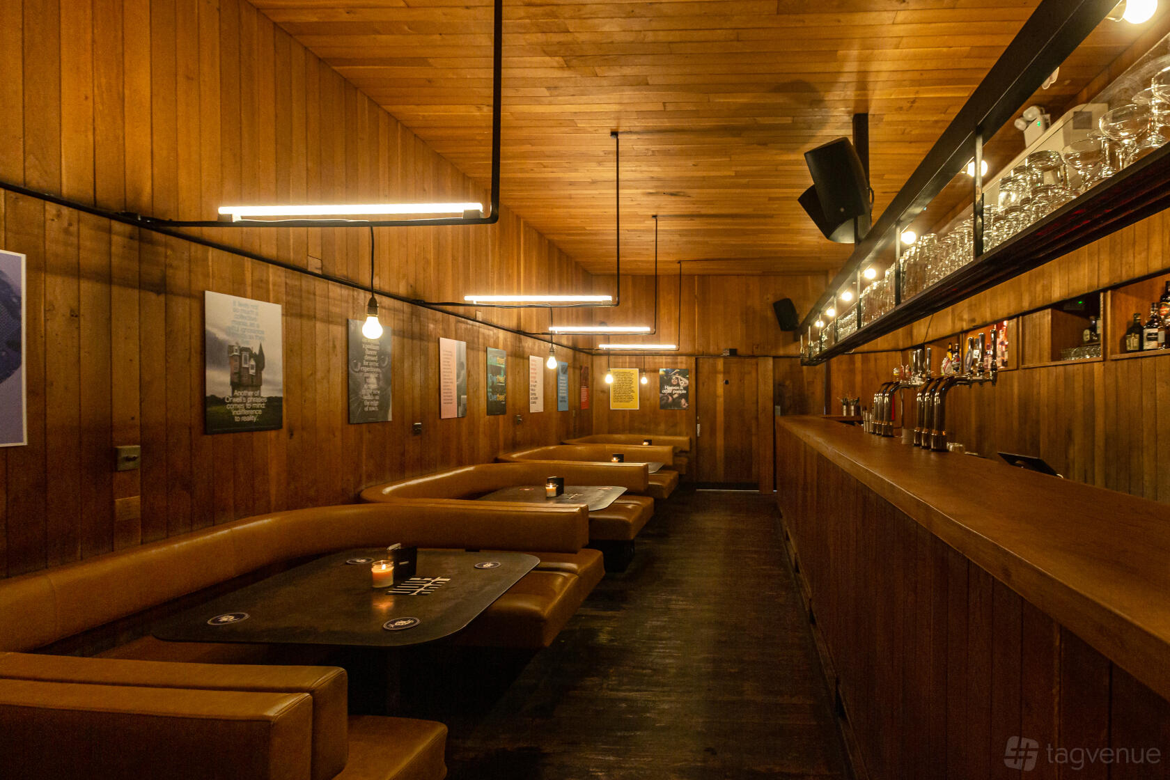 An event space with wood-paneled walls, leather booths, and warm overhead lighting at The Social.