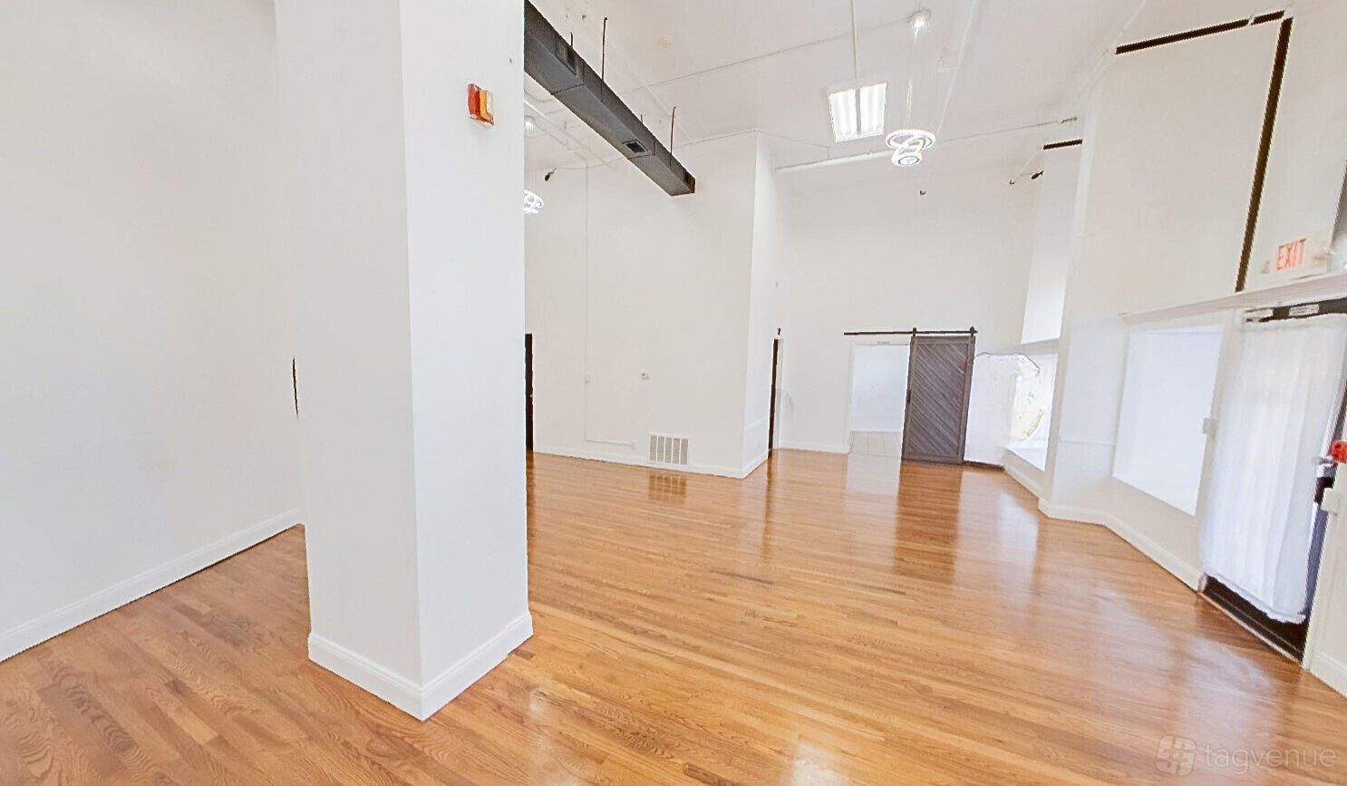 An event venue with polished hardwood floors, white walls, and tall ceilings at Sorella's Events, LLC.