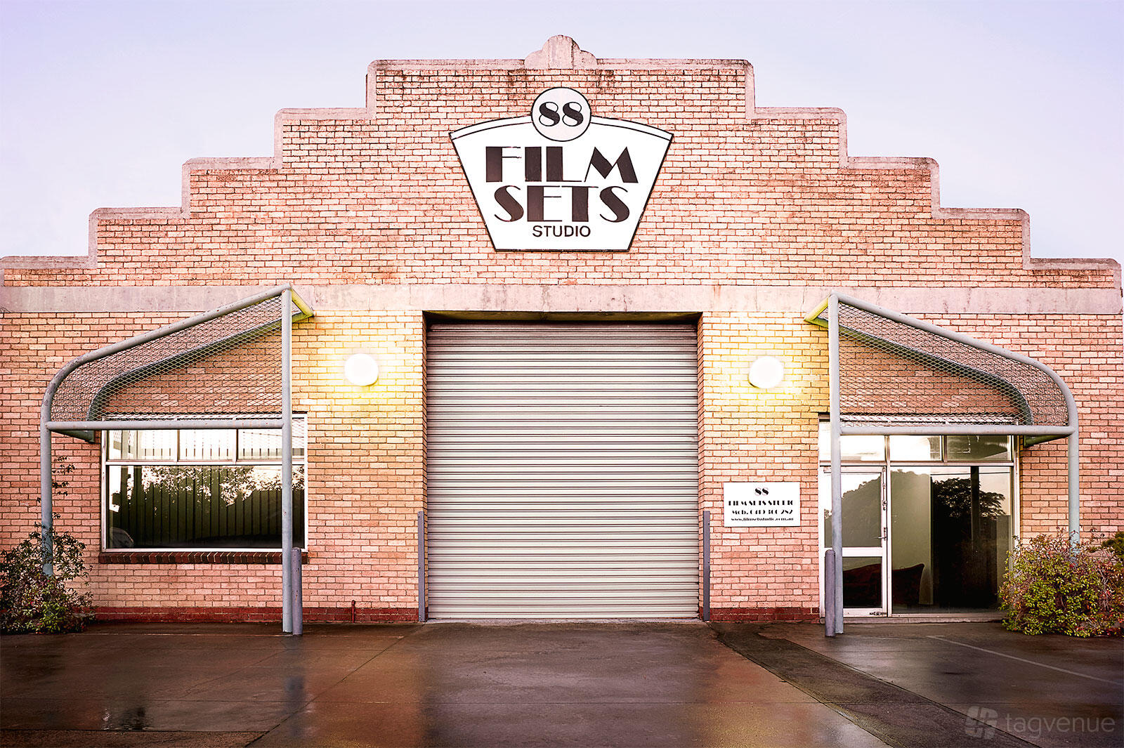 A film and photo studio with a brick facade, large roller door, and illuminated exterior lights at Filmsets Studio.