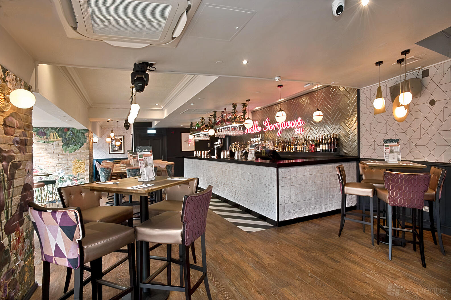 An event space in a bar with a herringbone tiled bar, pendant lighting, and high tables at Slug and Lettuce Chelmsford.