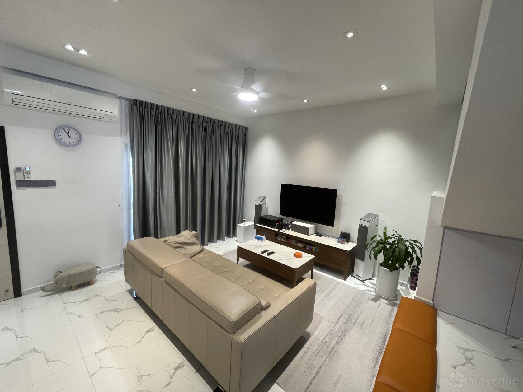 A living room with a beige sectional sofa, wall-mounted TV, marble tile flooring, and floor-length curtains at Modern Contemporary Home In The East.