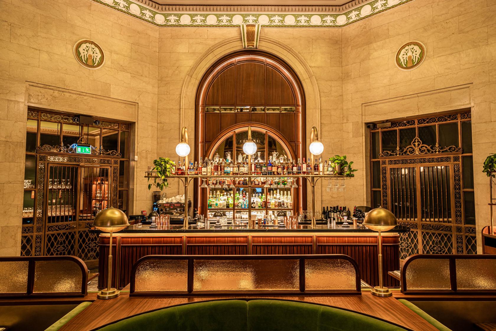 A restaurant with a marble bar, globe pendant lighting, and decorative brass accents at Hawksmoor Liverpool.