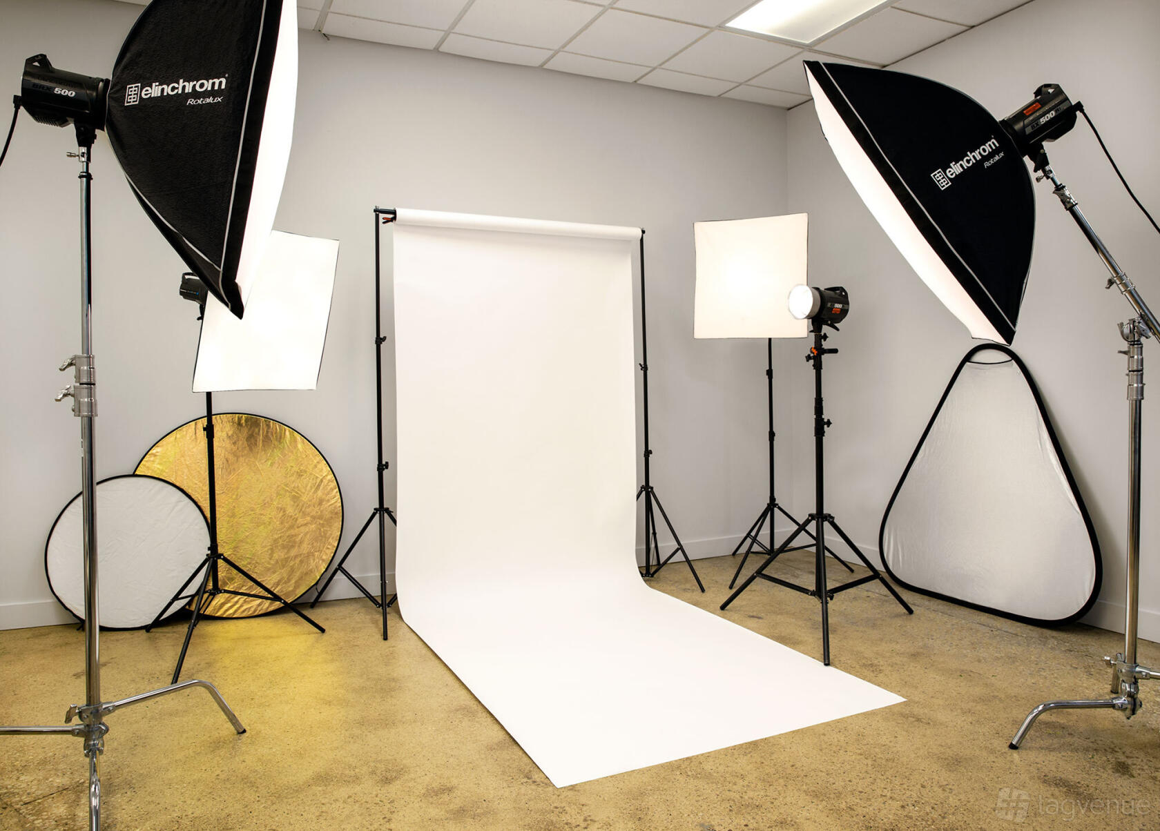 A photo studio with seamless white backdrop, softbox lighting, and reflective panels at MPP Photography Studio.
